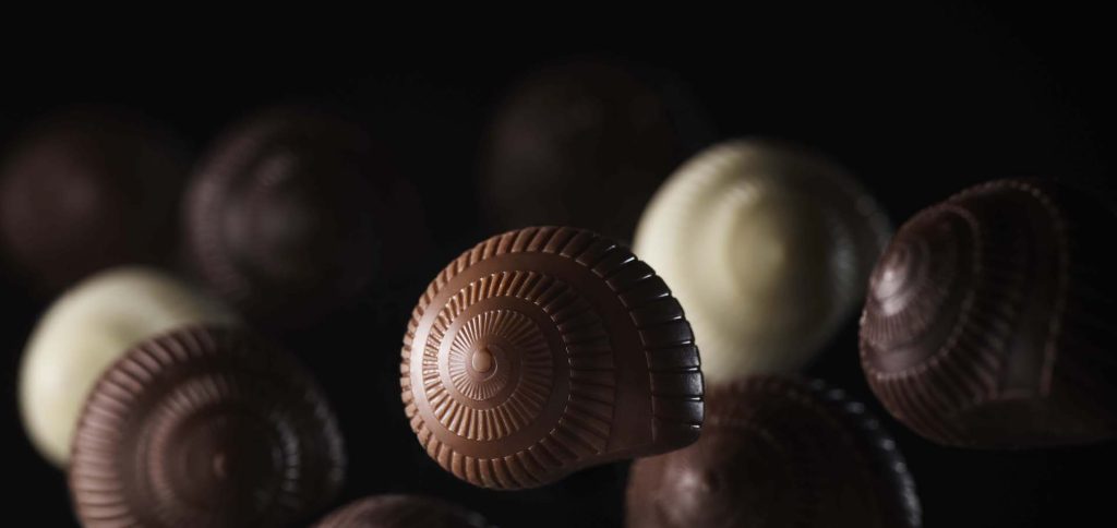 Escargots en chocolat présentés en gros plan sur fond sombre